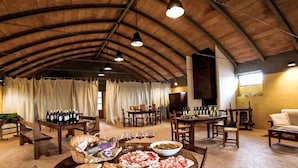 A rustic dining area with wooden tables, chairs, and a variety of food and drink items. - Nice apartment in villa for 2 guests with WIFI, A/C, pool, patio and panoramic view (Cinigiano)