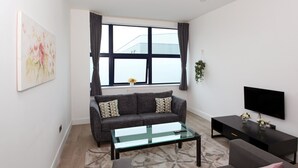 Een moderne woonkamer met een bank, salontafel en tv-meubel.