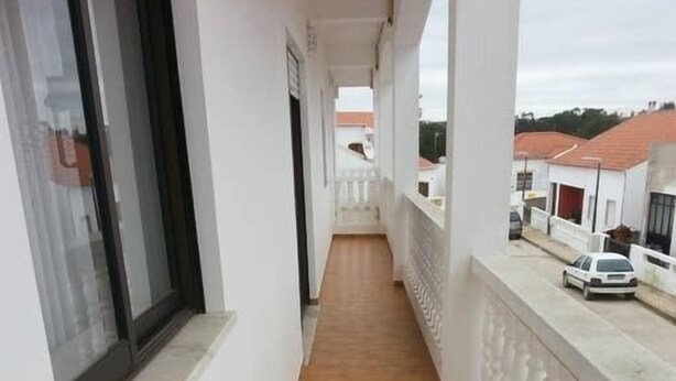 A narrow corridor with a tiled floor, white walls, and a balustrade. - Apartamentos Odeceixe (Aljezur)