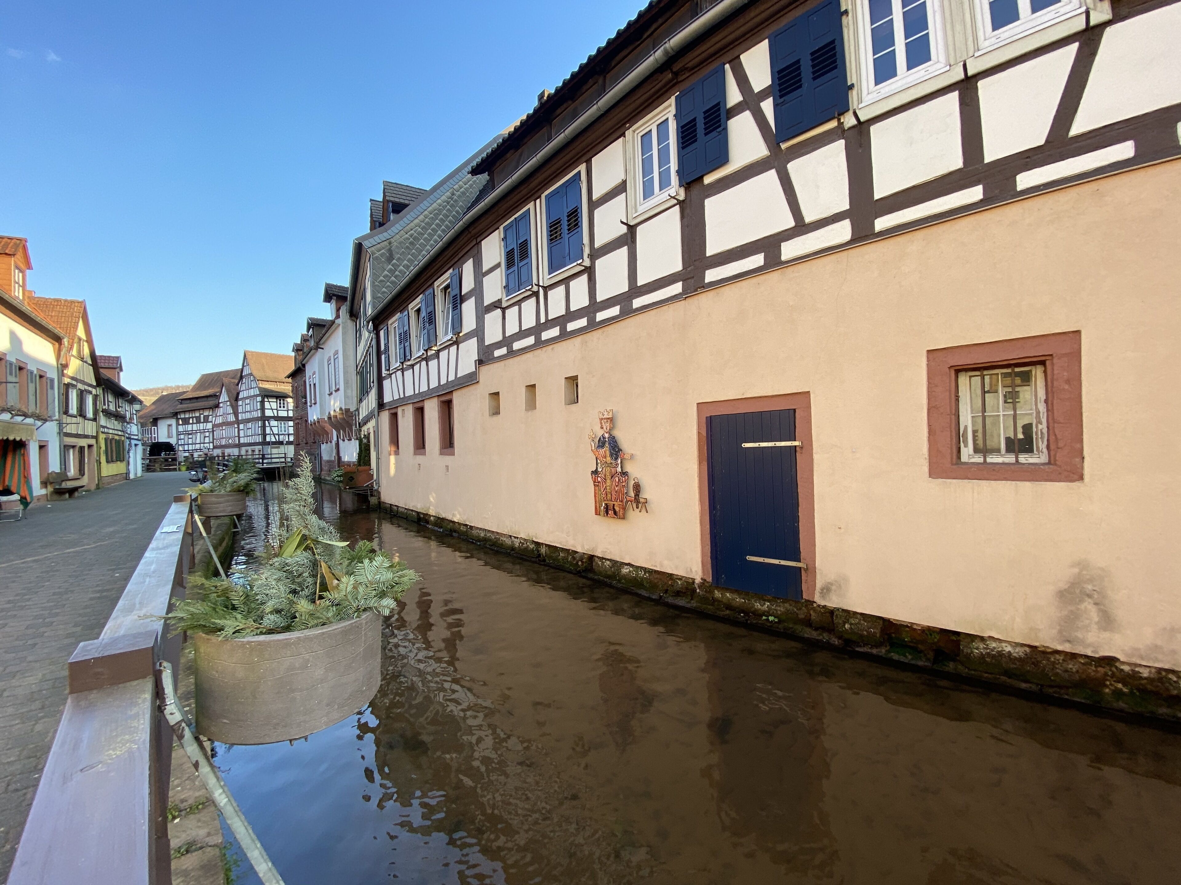 A narrow waterway flanked by traditional half-timbered buildings with a canal on one side.