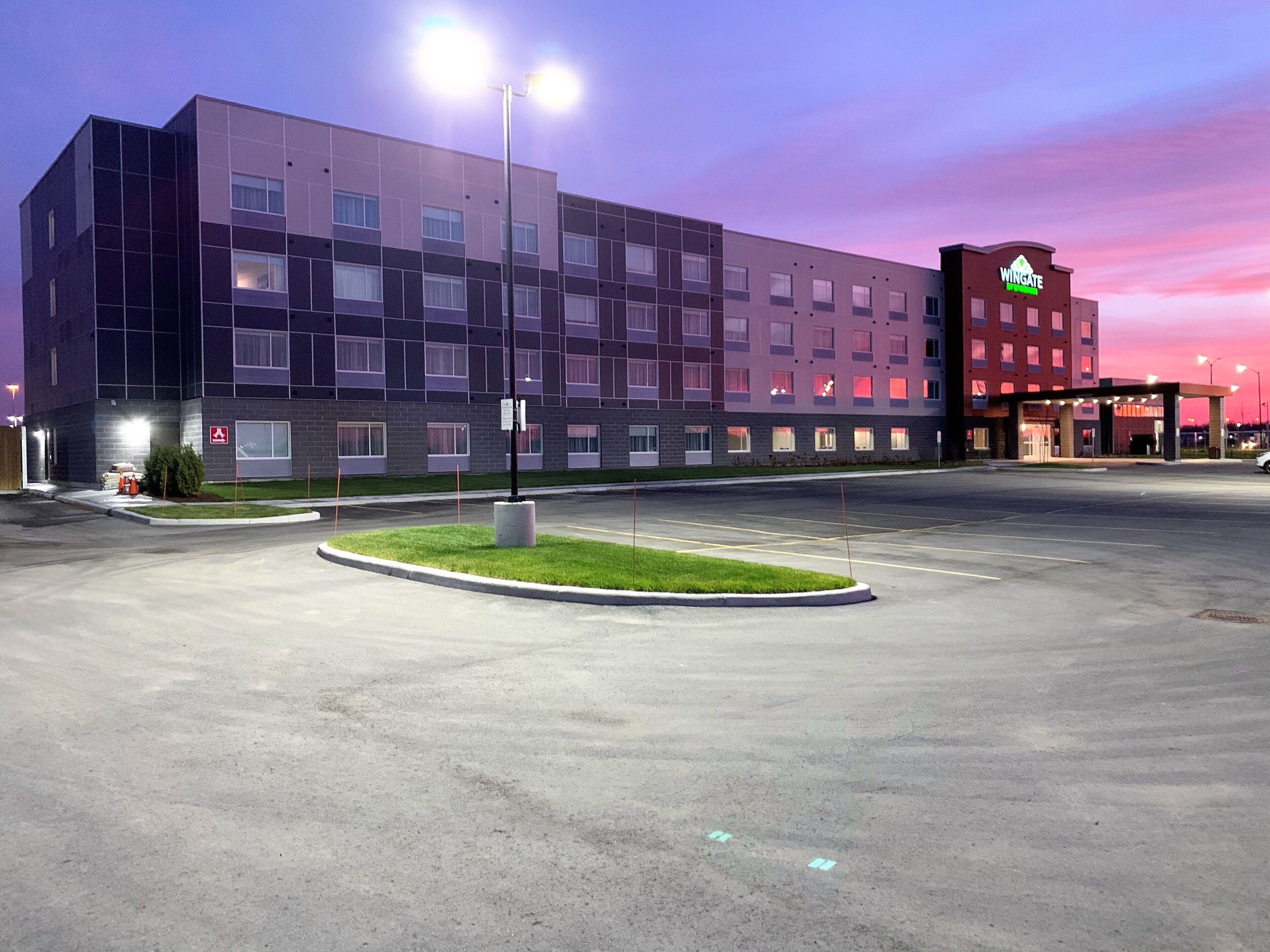Un hotel moderno con aparcamiento y zonas ajardinadas.