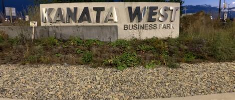 Segnaletica per il Kanata West Business Park, con un vialetto sterrato di fronte.
