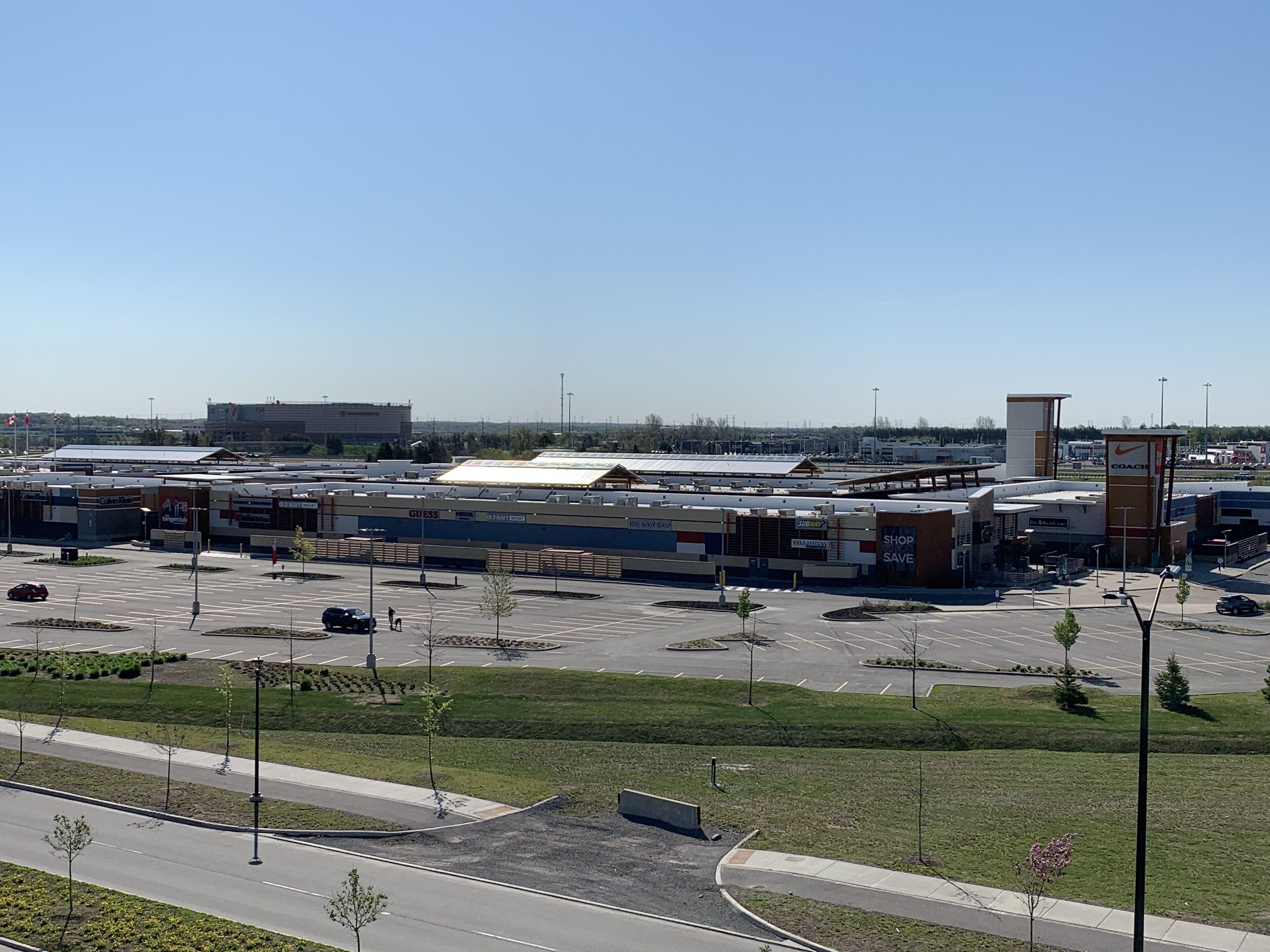A large parking lot with multiple commercial buildings, including a visible sign for a Nike store.