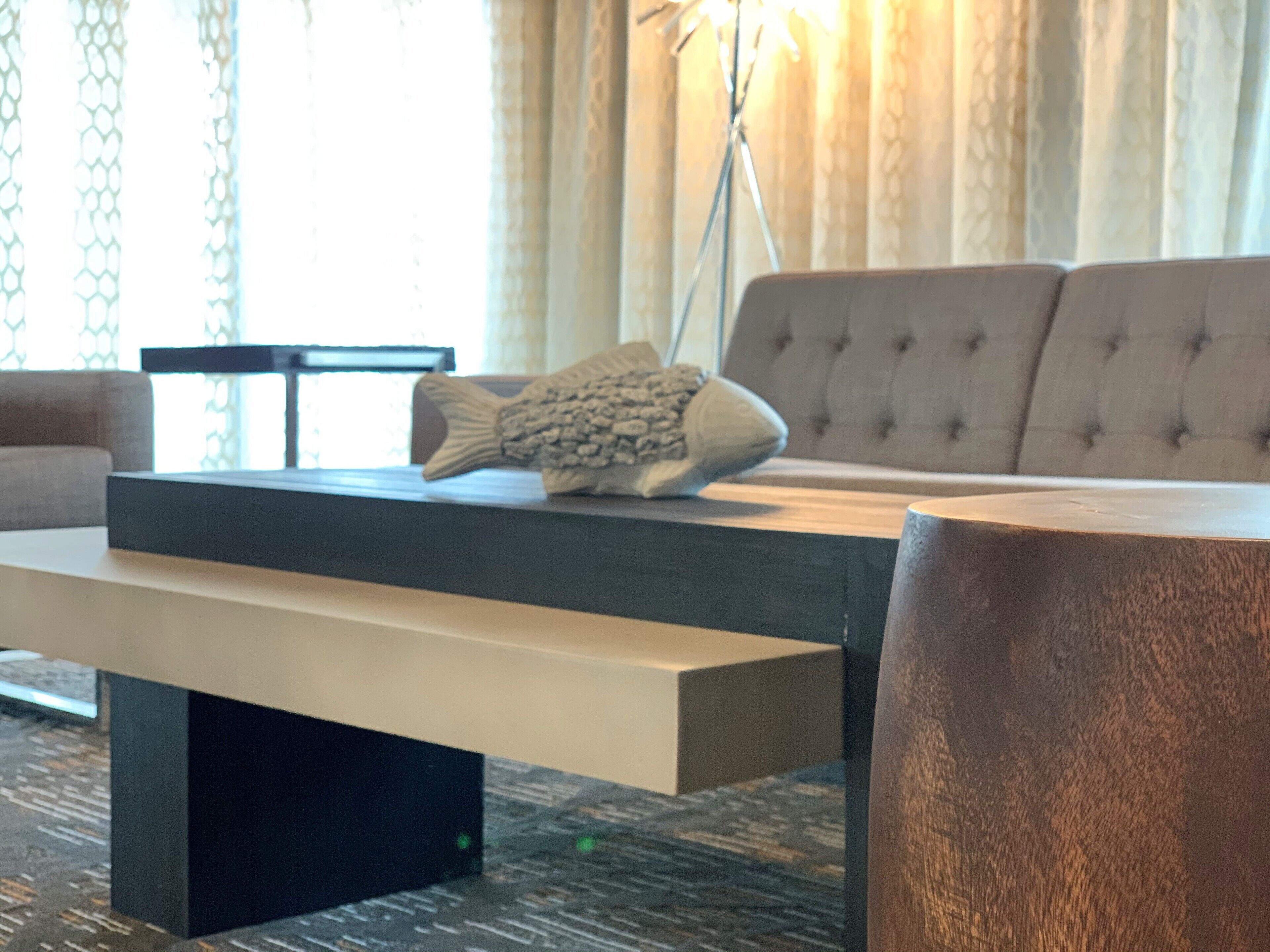 Een moderne woonkamer met een bank, een salontafel en een lamp.