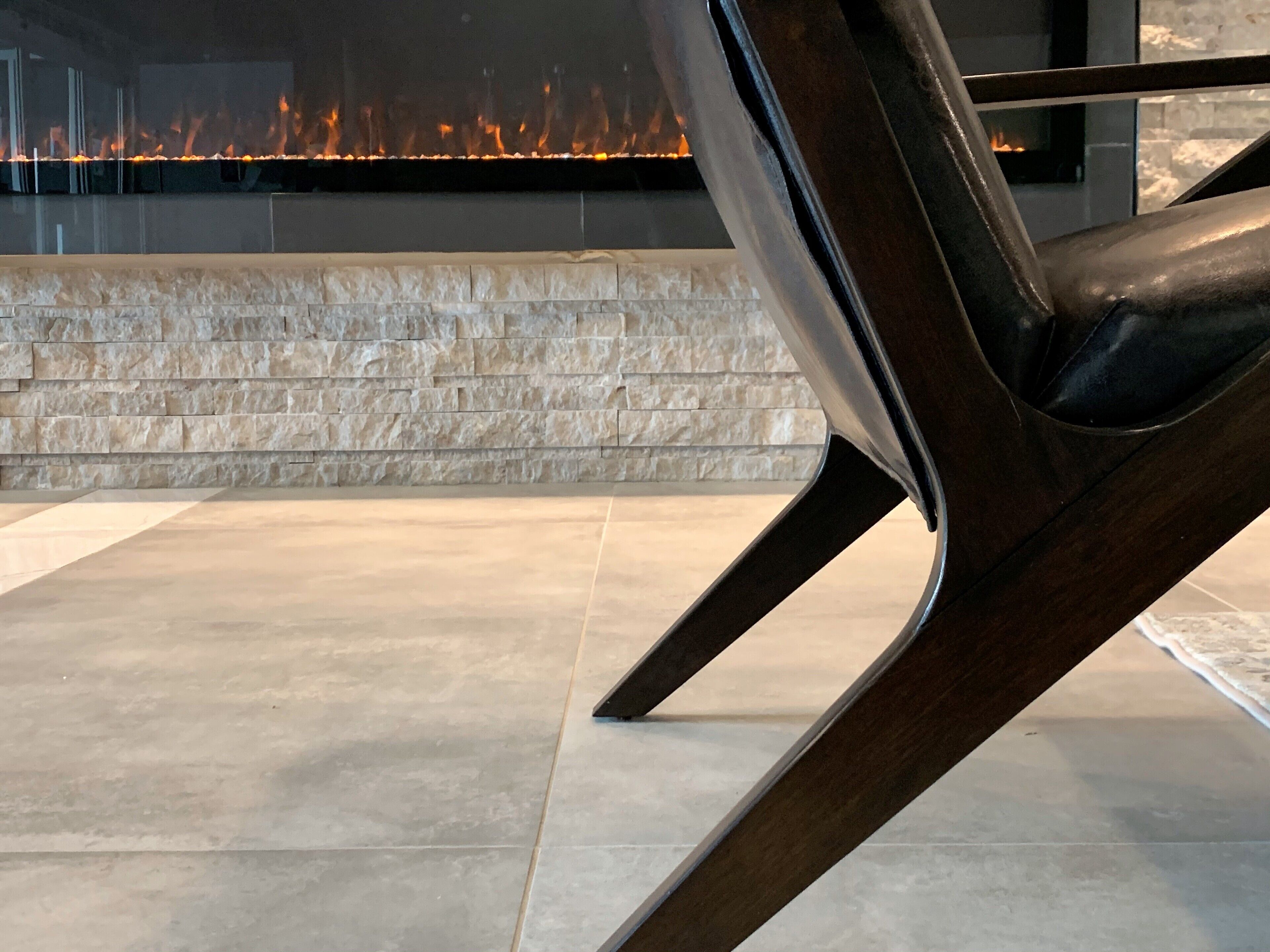 A modern interior with a stone wall and a fire feature.