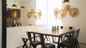 A dining area with a wooden table, black chairs, and three pendant lights. - Central Luxury house - Condesa Neighborhood (Colonia Condesa)