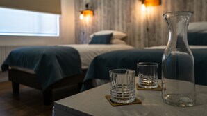 A hotel room with a bed, bedside tables, and a vase. - Hotel Boutique Restaurant Kran Kreen (Punta Arenas)