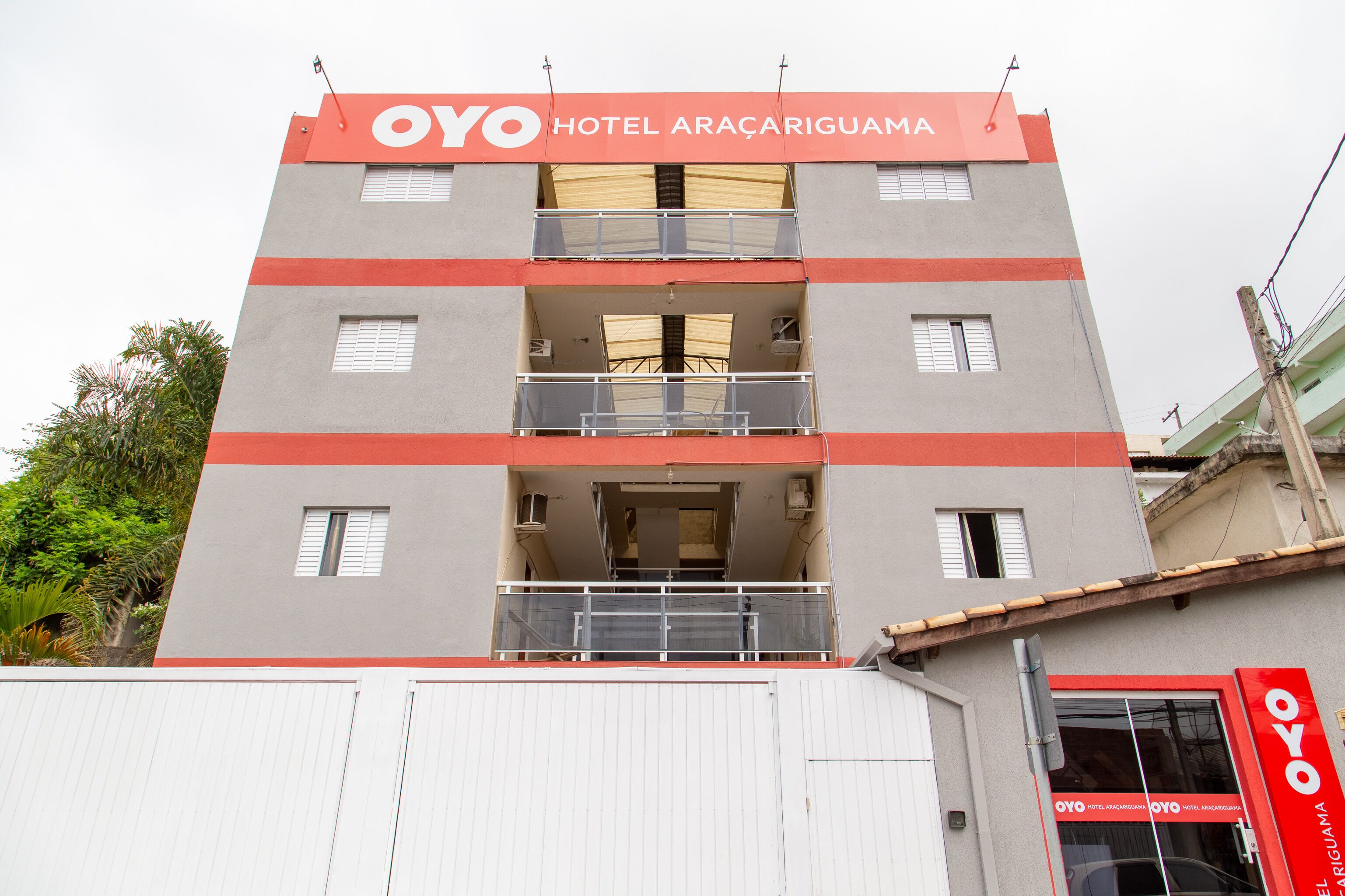 A multi-story hotel building with balconies and a prominent red and grey color scheme.
