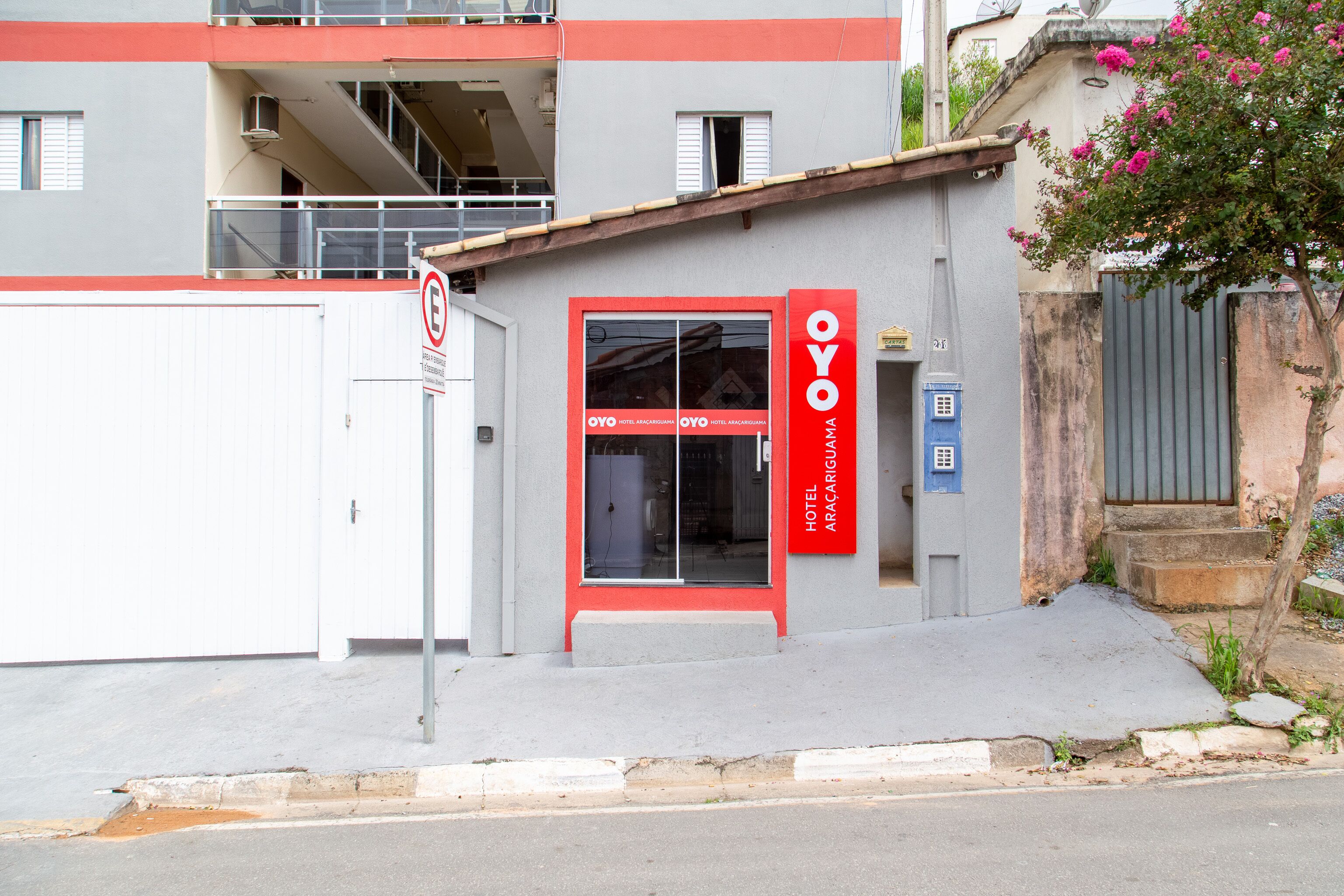 L'ingresso di un hotel con un cartello rosso, una cassetta postale e una scala che conduce a un piano superiore.
