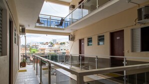 Un immeuble à plusieurs étages doté de balcons, de garde-corps et offrant une vue sur les environs.