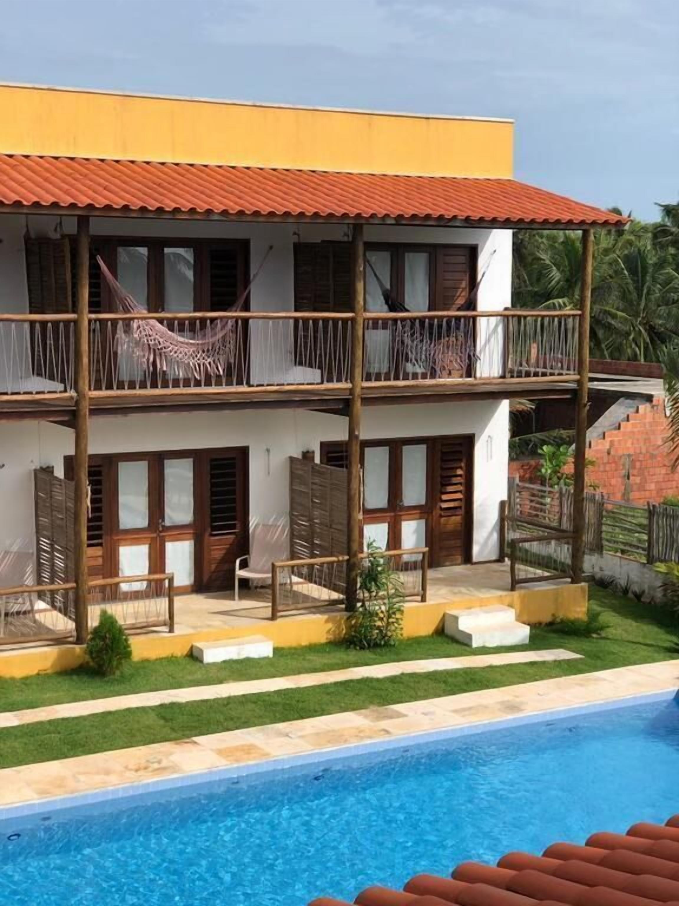 A two-story building with a swimming pool in the foreground.