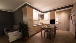 Eine moderne Küche mit Holzausstattung, einem Esstisch und einer Couch.
