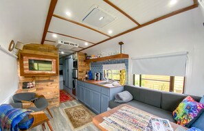 Ein kompaktes Wohnmobil-Interieur mit Küchenzeile, einer Sitzecke und einem kleinen Esstisch.