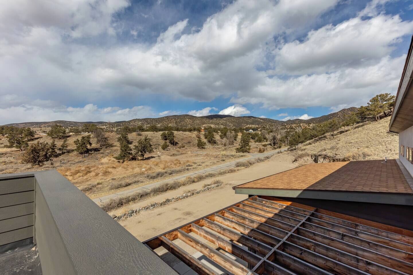 A modern building with a flat roof and a view of a dry, hilly landscape.