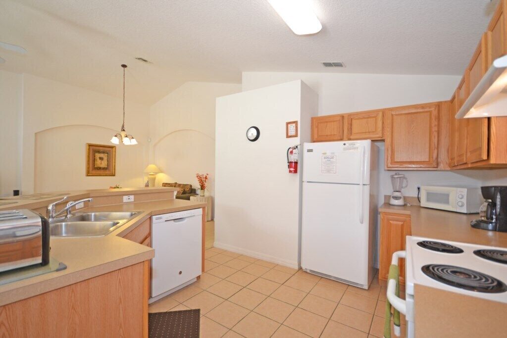 A compact kitchen with a dishwasher, refrigerator, microwave, and stove.