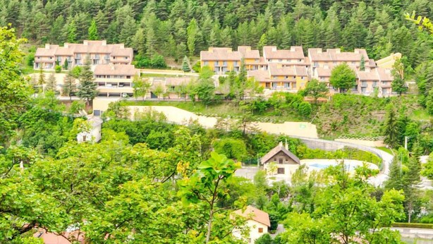 Un quartier résidentiel composé d’immeubles à plusieurs étages, entouré d’une végétation luxuriante et d’arbres.