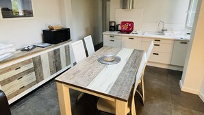 A compact kitchen with a dining area, featuring a microwave, coffee maker, and a red appliance on the counter. - House and its pool near the beach (Andernos-les-Bains)