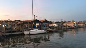 A marina with boats docked, wooden structures, and a calm water body. - House and its pool near the beach (Andernos-les-Bains)