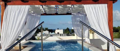 Piscina com vista para edifícios e um céu claro.