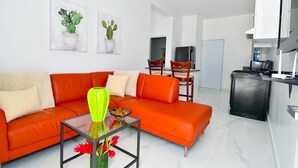 A modern living room with a sofa, a glass coffee table, and artwork on the wall. - Rosil Place (Puerto Plata)