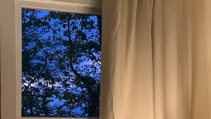 Une pièce avec une fenêtre, une lampe et une chaise.