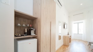 A modern kitchen with a built-in refrigerator, a coffee machine, and a wooden shelf with kitchenware. - Eugenia e Donato (Naples)