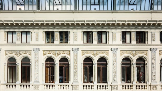 A classical building facade with ornate architectural details, large arched windows, and a balcony. - Eugenia e Donato (Naples)