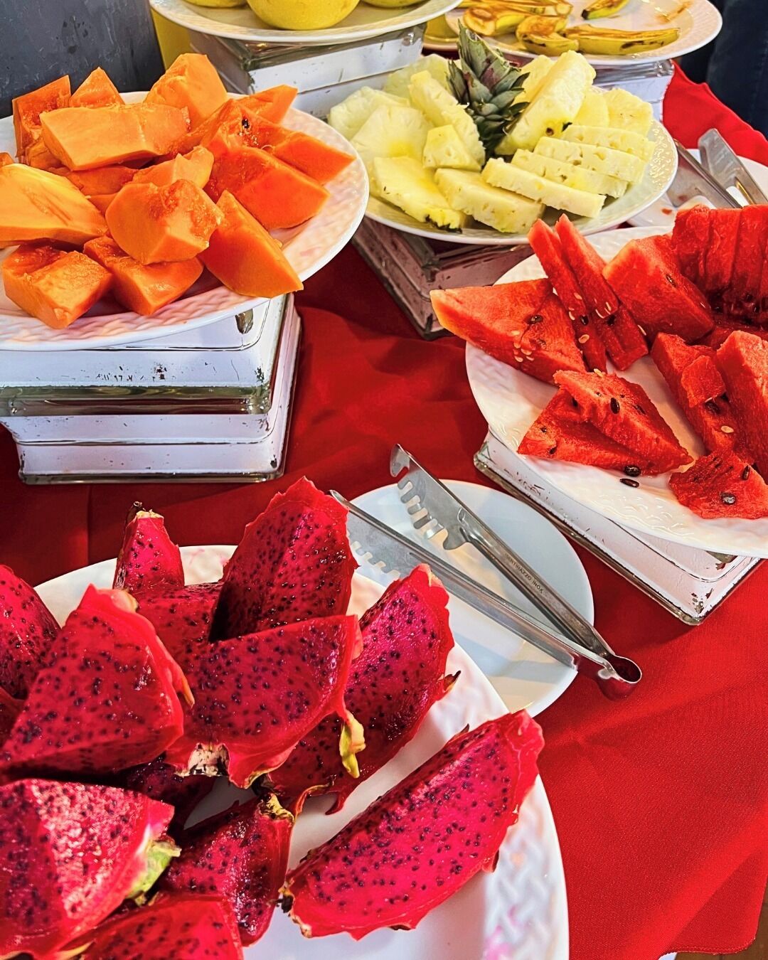 Taula de buffet amb diverses fruites, com ara papaya, pineapple, sandía i pitahaya.