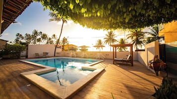 Una piscina al aire libre, sillones reclinables de piscina