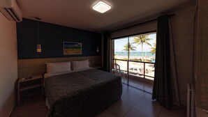 A hotel room with a large bed, a nightstand, a window with a view of the beach, and a ceiling light. - Pousada Mariluz (Maragogi)