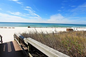 A beach with a wooden boardwalk leading to the shore, clear blue sky, and calm ocean. - 🌊Walk to Beach-Balcony-Pool-Southwind I-9🌊 (Panama City Beach)