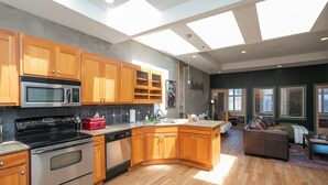 A modern kitchen with wooden cabinets, stainless steel appliances, and a large island.