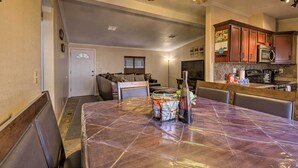 A dining area with a large table, chairs, and a kitchen in the background. - 3 Mi to Lake Powell: Page Home w/ Patio & BBQ (Page)