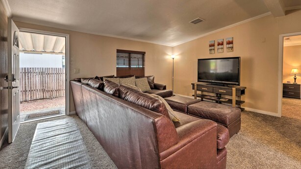 A living room with a sectional sofa, a flat-screen TV, and a fireplace. - 3 Mi to Lake Powell: Page Home w/ Patio & BBQ (Page)
