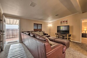 A living room with a sectional sofa, a flat-screen TV, and a fireplace. - 3 Mi to Lake Powell: Page Home w/ Patio & BBQ (Page)