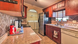 A kitchen with wooden cabinets, a stainless steel refrigerator, a dishwasher, and a granite countertop. - 3 Mi to Lake Powell: Page Home w/ Patio & BBQ (Page)