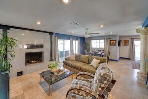 A spacious living room with a fireplace, a large sofa, a coffee table, and a dining area in the background. - Las Vegas Pit Stop w/ Private Hot Tub (Las Vegas)