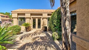 A house with a tiled roof, a front door, and a window. There is a palm tree and a bush in the front yard. - 4 Mi to TPC Scottsdale: Family Home w/ Hot Tub! (Scottsdale)