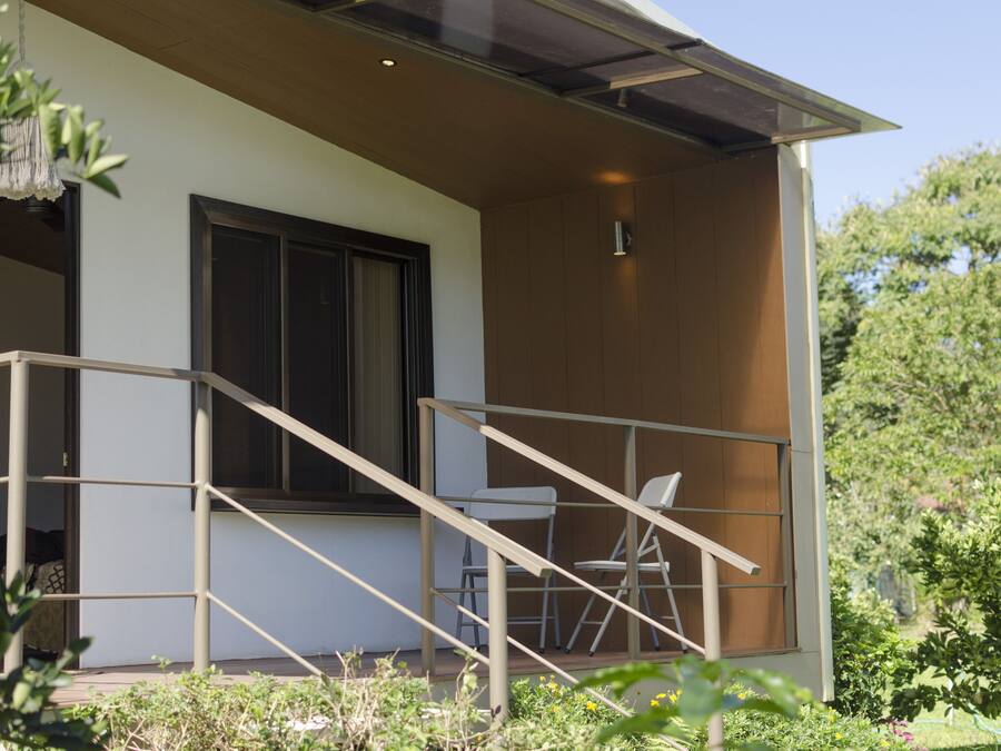 A modern building with a balcony, a chair, and a staircase.