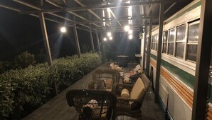Un espace extérieur aménagé avec des meubles en osier et une structure couverte.