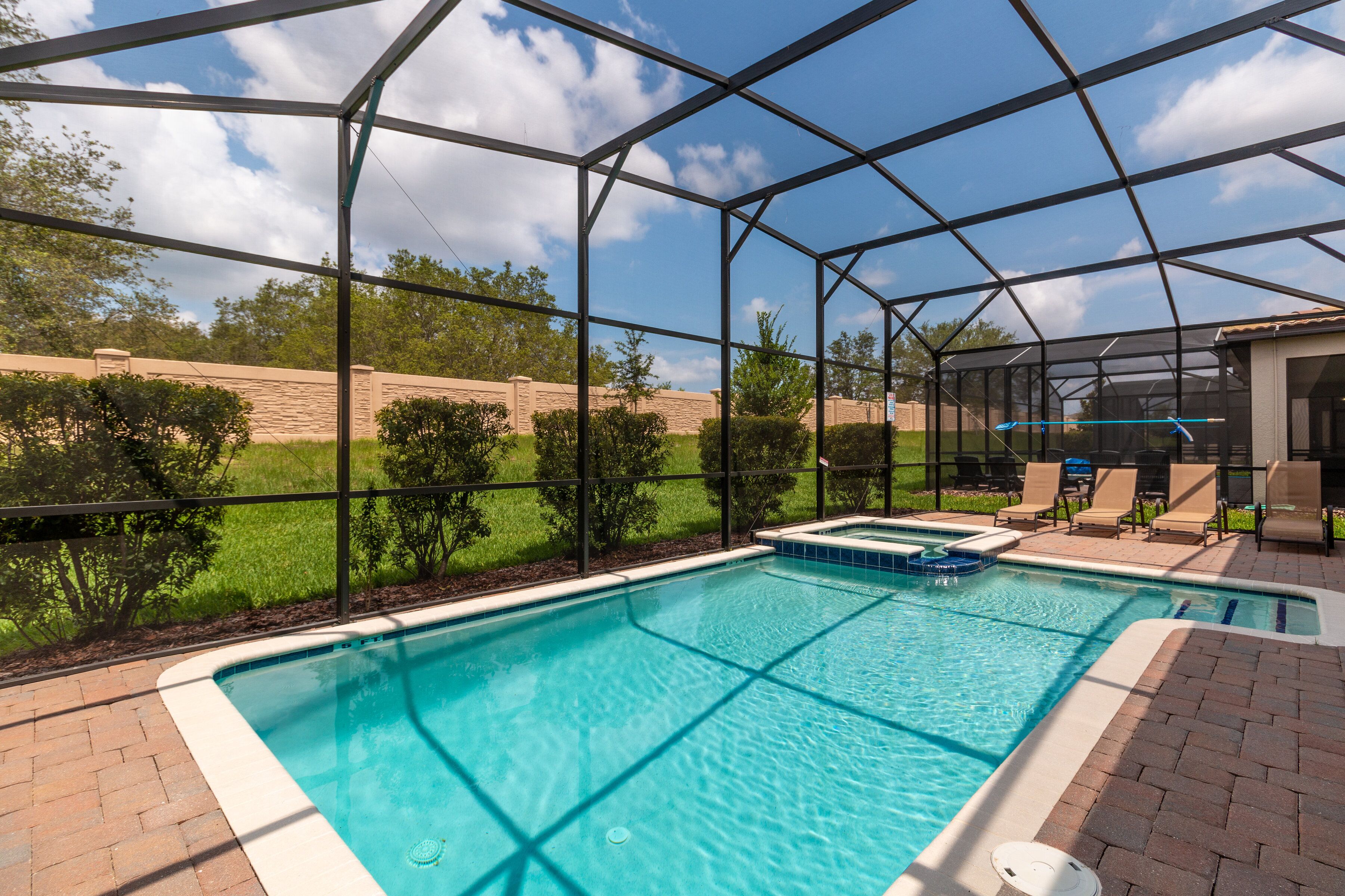 A rectangular pool with a clear blue water surface, surrounded by a black metal fence.