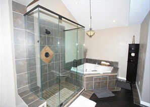 A modern bathroom with a glass-enclosed shower, a freestanding bathtub, and a dark floor. - Casa De Paradisio 2 by Destin Getaways (Miramar Beach)