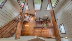 A multi-level wooden interior with skylights, wooden stairs, and a central staircase.