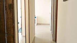 Un pasillo con paneles de madera, paredes blancas y piso de baldosas.
