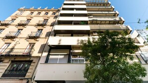 A multi-story building with balconies and a tree in the foreground. - Holi-Rent Martín Villa (Sevilla)