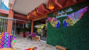 A vibrant outdoor seating area with colorful chairs and a neon sign for Santa Marta @ sorontobeach. - Hotel Sorrento Santa Marta (Santa Marta)