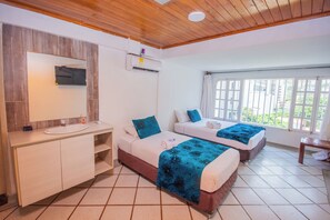 Una habitación de hotel con dos camas, un baño y una ventana con vistas.