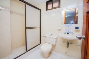 Un baño con inodoro, lavamanos y ducha.