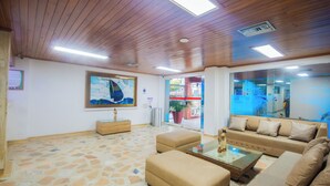 A spacious living area with a wooden ceiling, a large painting, a sofa, and a coffee table. - Hotel Sorrento Santa Marta (Santa Marta)
