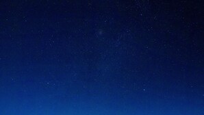 A desert campsite at night with a campfire and people gathered around. - Dar Marhaba (Taouz)